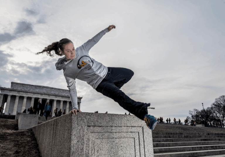 A person doing parkour in front of the Lincoln Memorial